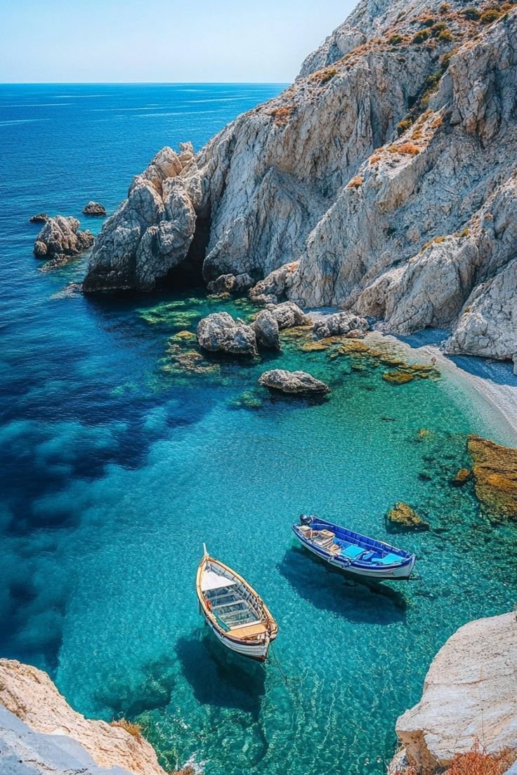 This may contain: two boats are sitting in the clear blue water