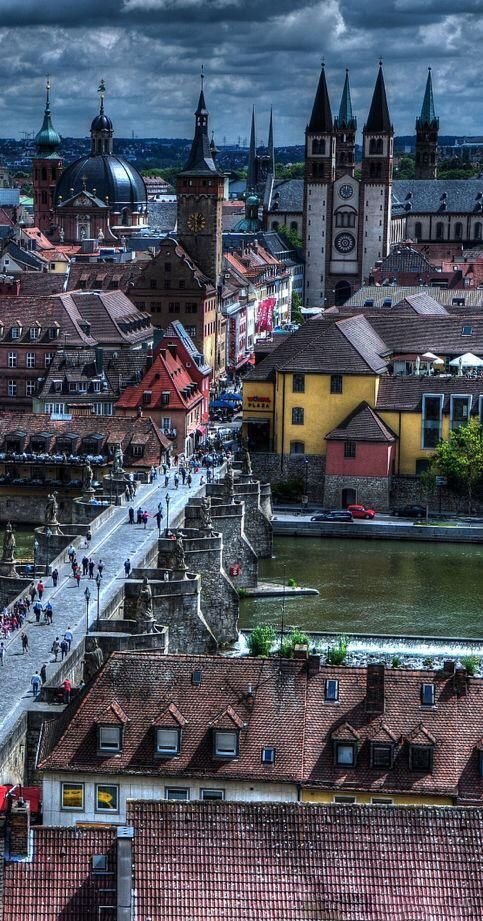 This may contain: an aerial view of a city with many buildings and people walking on the sidewalk in front of it