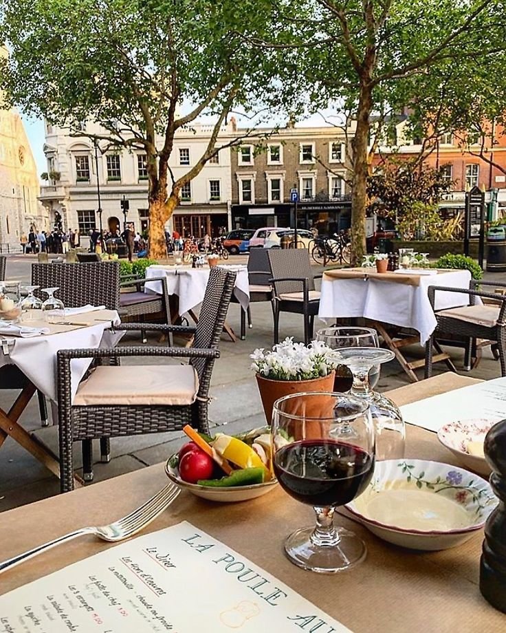 This may contain: an outdoor dining area with tables, chairs and menus on the table in front of it