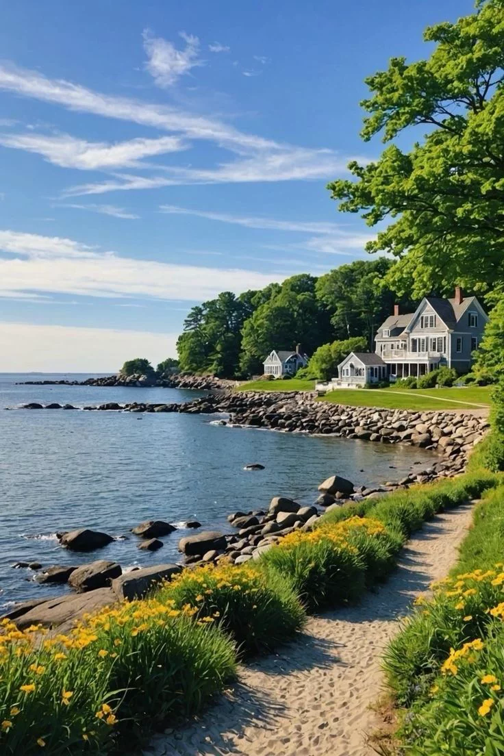 This may contain: a house sitting on top of a lush green hillside next to the ocean with yellow flowers in front of it