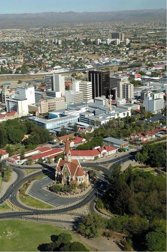This may contain: an aerial view of a city with many buildings and roads in the middle of it