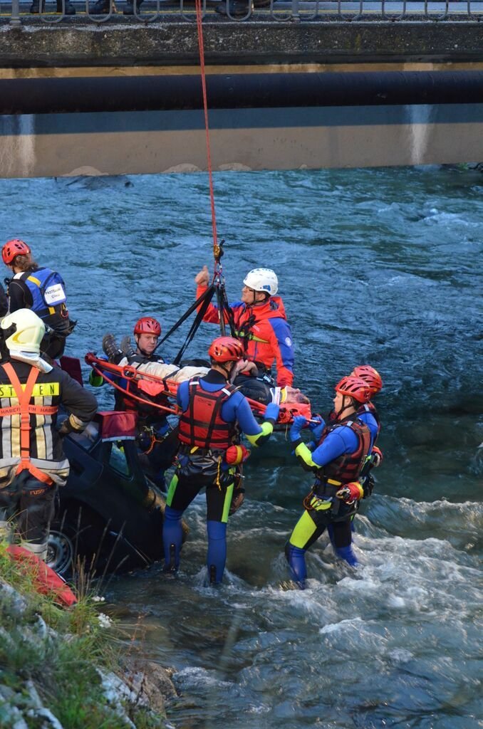 This may contain: several people in life jackets and safety vests standing next to a raft