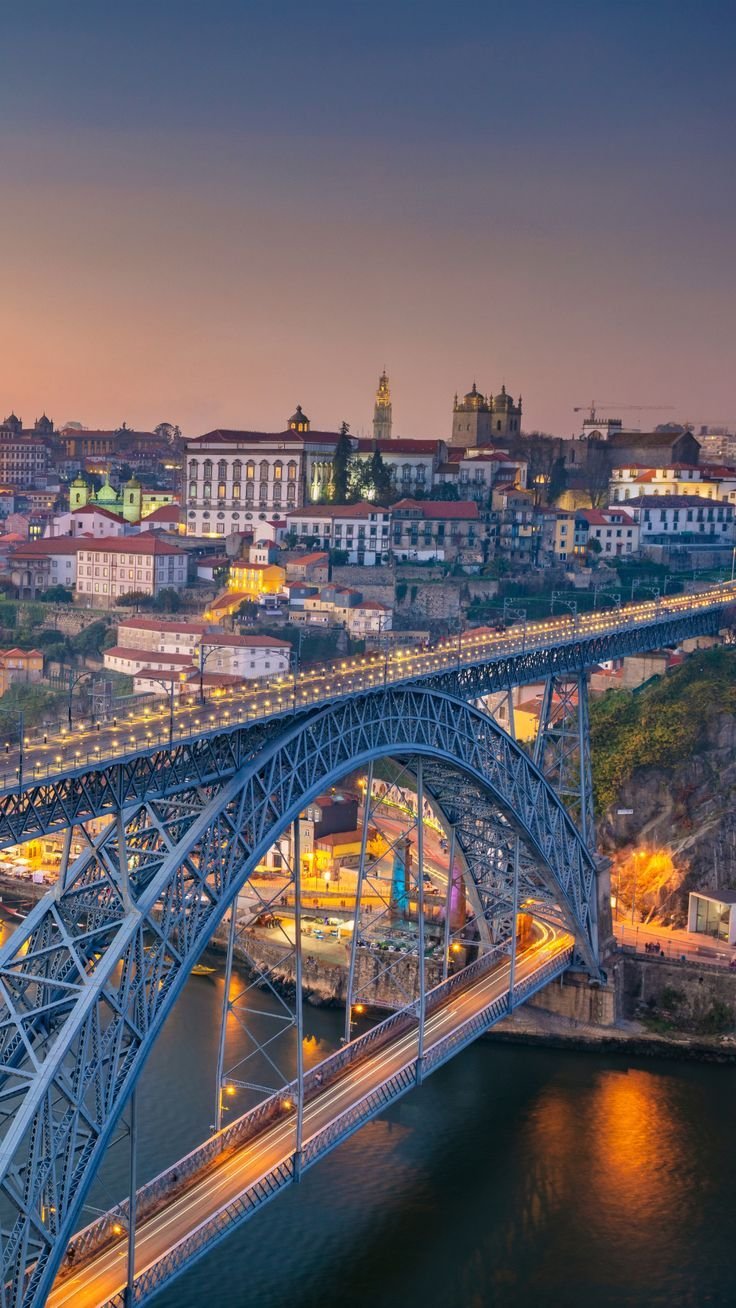 This may contain: an aerial view of a bridge over a river at night