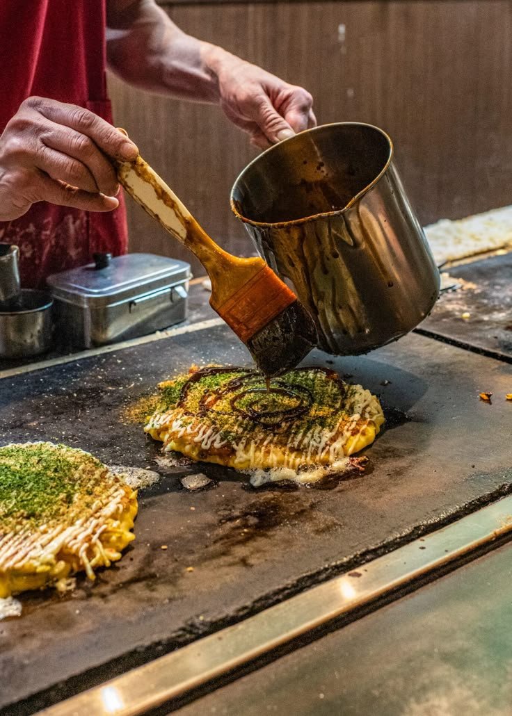 This may contain: a man cooking food on top of a grill with a spatula in his hand