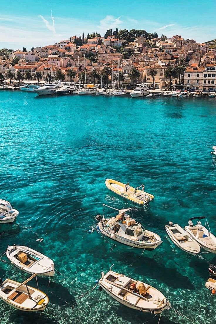 This may contain: many small boats are in the clear blue water