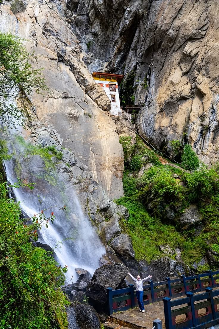 This contains: Waterfall near cliffside Tiger's Nest monastery