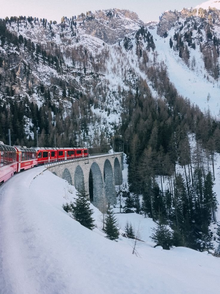 This contains: Bernina express Switzerland alps , across old stone arch bridges, winter wonderland, travel dreams