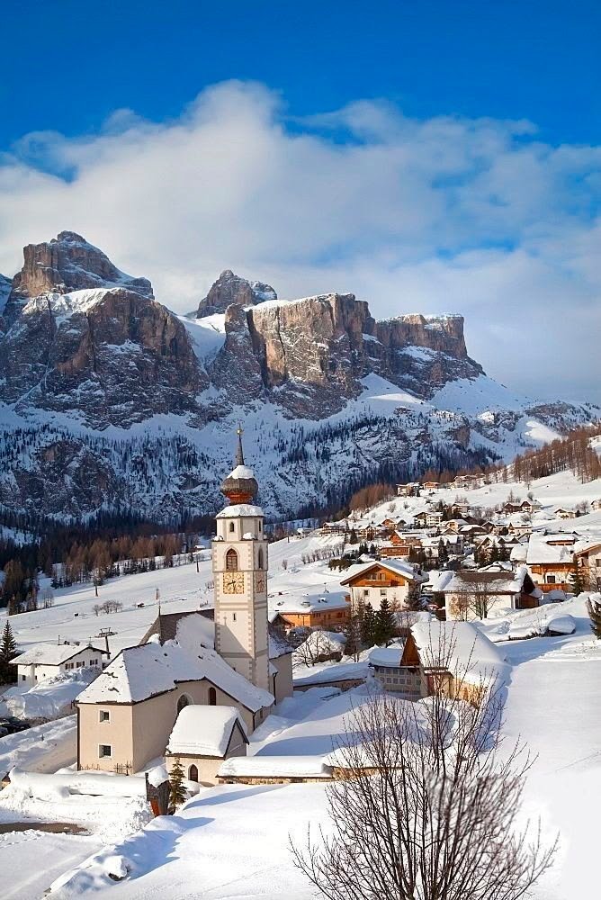 This may contain: a snowy mountain town with mountains in the background and snow on the ground around it