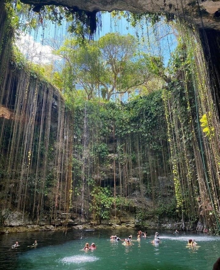 This may contain: people are swimming in the water inside a cave