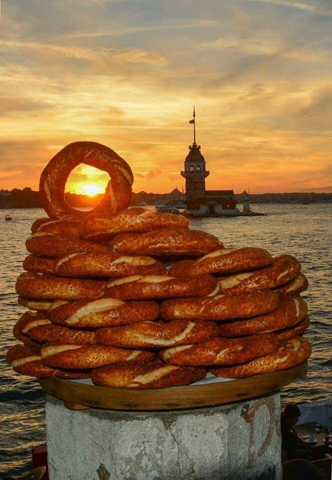 This may contain: a stack of pretzels sitting on top of a cement block in front of the ocean