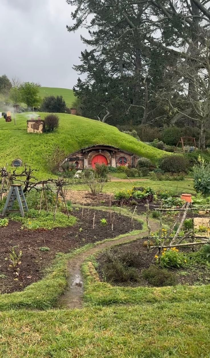 This may contain: the hobbot house is surrounded by lush green grass