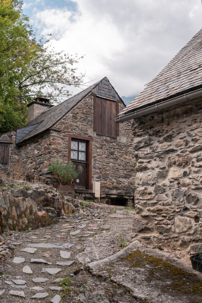 This may contain: an old stone building sitting next to a forest