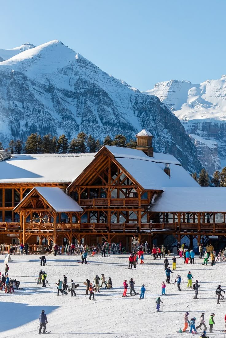 This may contain: a large group of people standing outside of a building on top of snow covered ground