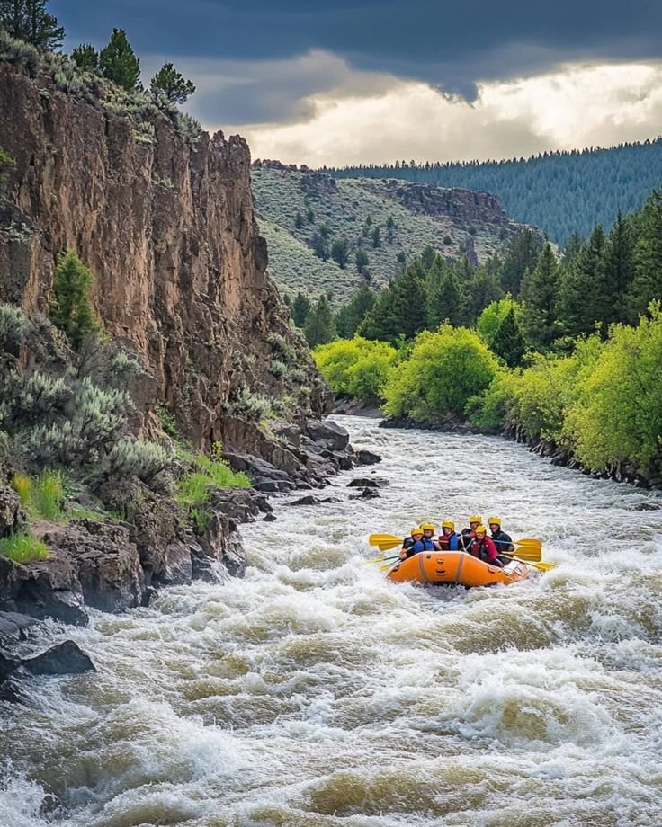 This may contain: a group of people riding on top of a raft down a river