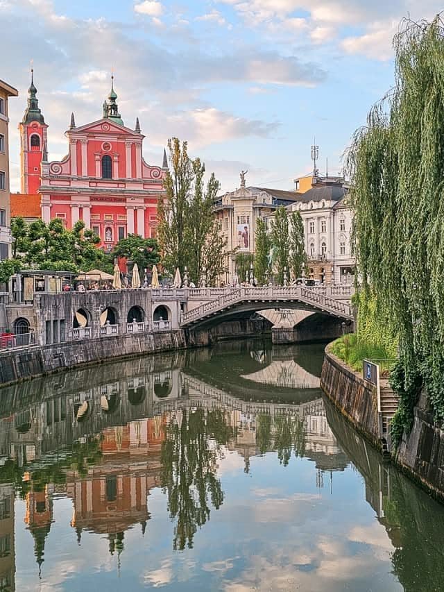 This may contain: a river running through a city with tall buildings on both sides and a bridge in the middle