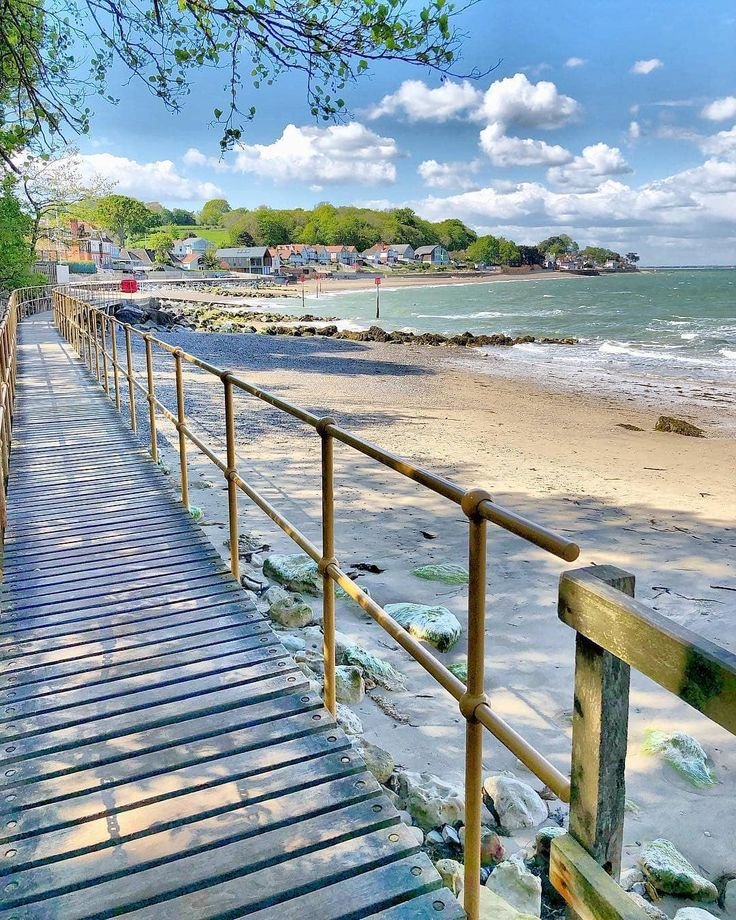 This may contain: a wooden walkway leading down to the beach