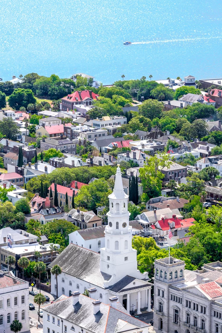 This may contain: an aerial view of a city with white buildings and a steeple in the background