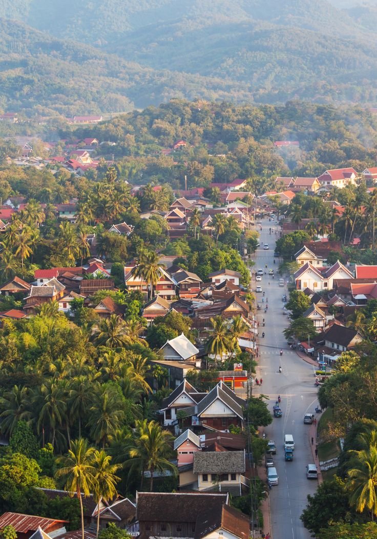 This may contain: an aerial view of a small town with mountains in the background