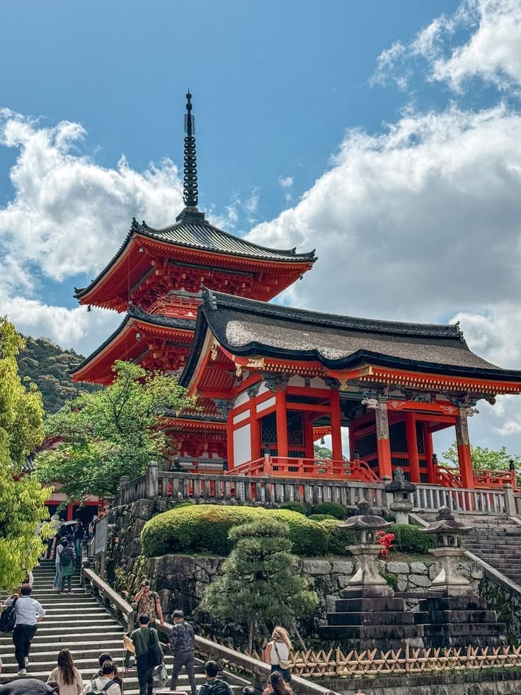 This may contain: people are walking up and down the stairs in front of a pagoda