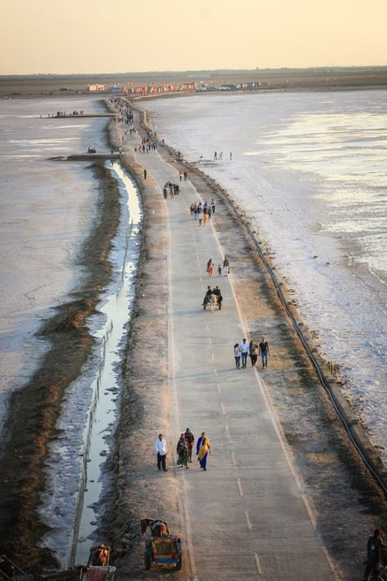 This may contain: people walking along the beach on a cold winter's day with no one in sight