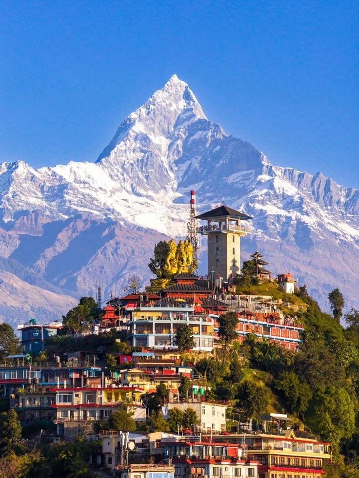This may contain: a large mountain covered in snow with buildings on top