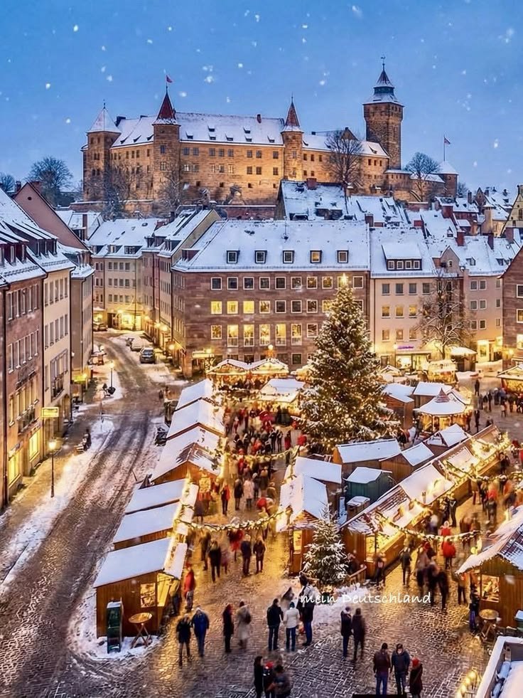 This may contain: an aerial view of the christmas market in old town, with snow falling on the ground