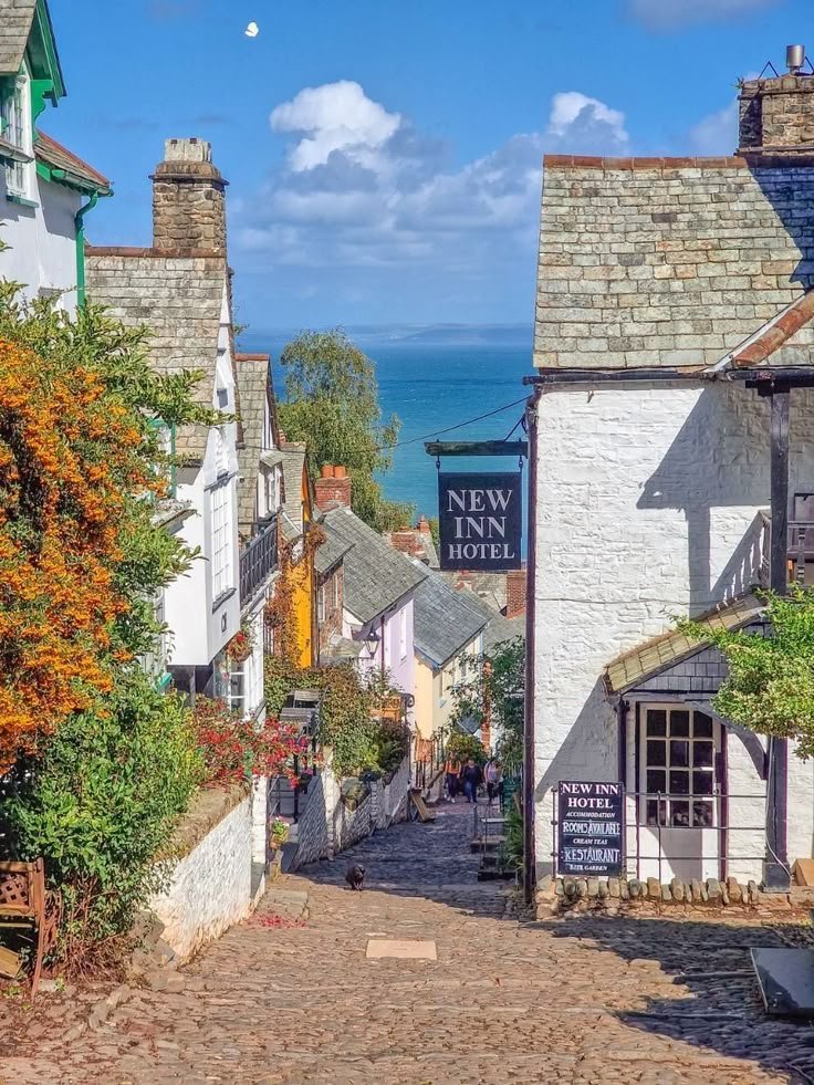 This may contain: an old cobblestone street leading up to the inn on the cliff above the water