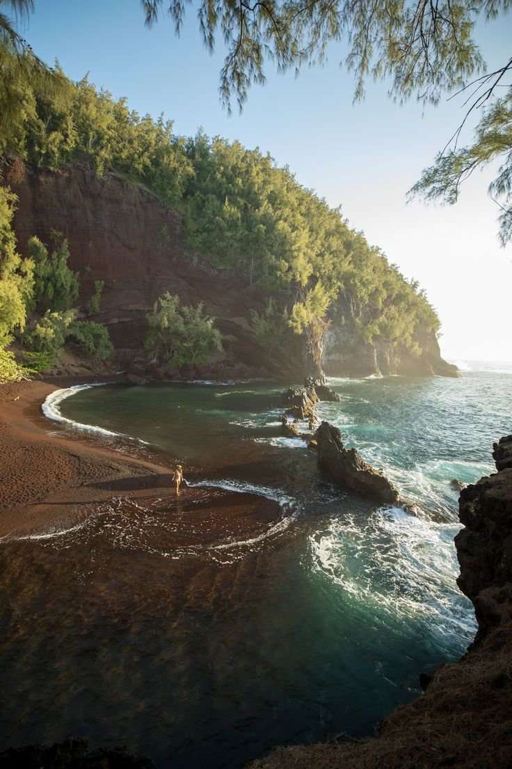 This may contain: a person standing on the edge of a cliff near the ocean