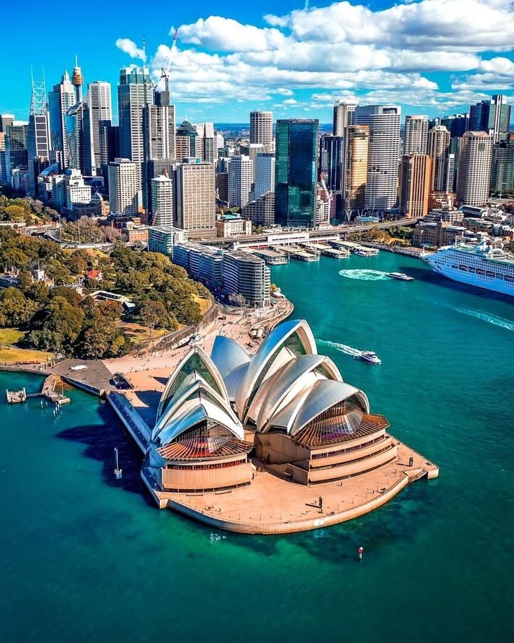 This may contain: an aerial view of sydney, australia with the opera house in the foreground and city buildings in the background