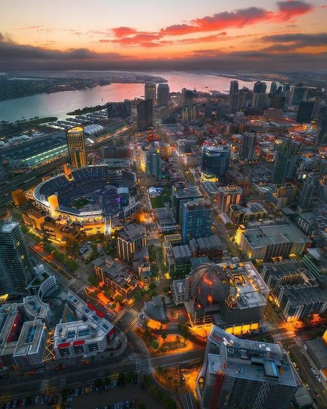This may contain: an aerial view of a city at night with the lights on and buildings lit up