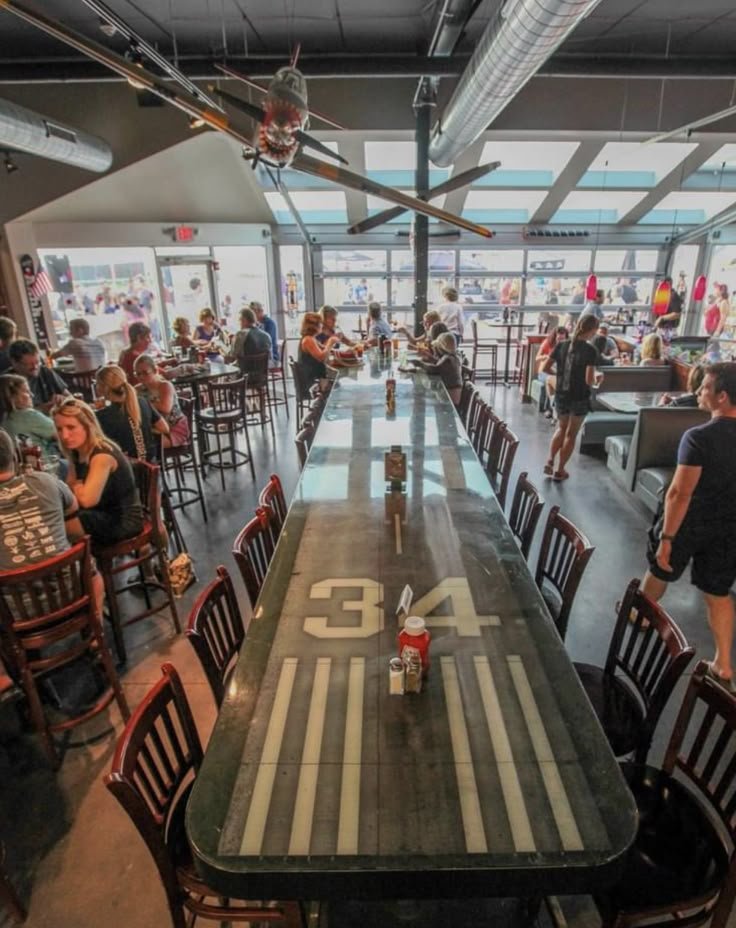 This may contain: people are sitting at tables in a restaurant