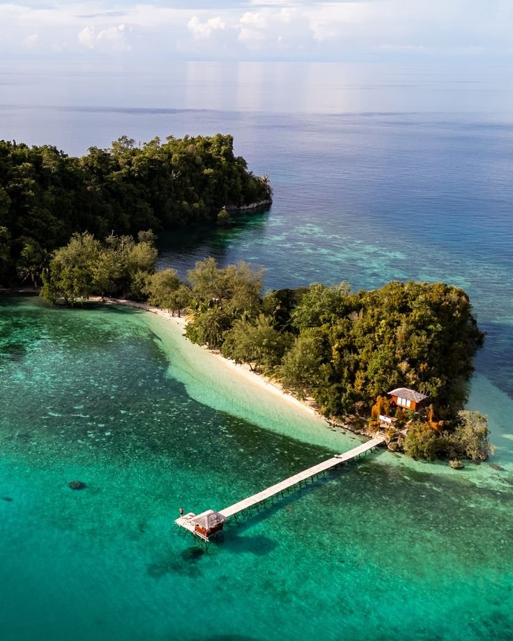 This may contain: an island in the middle of some water with a house on it's end