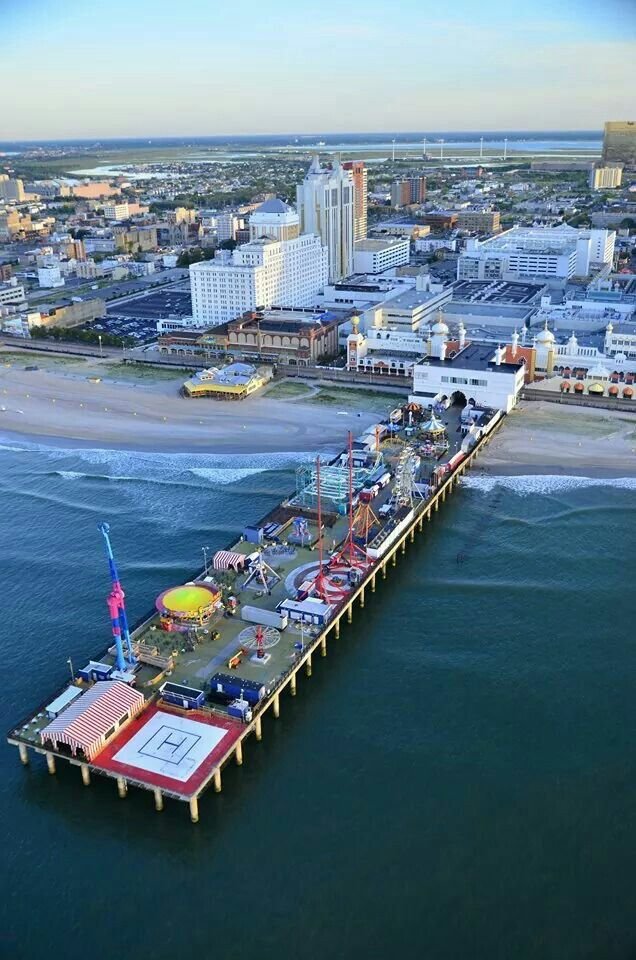 This may contain: an aerial view of a pier in the middle of the ocean with buildings around it