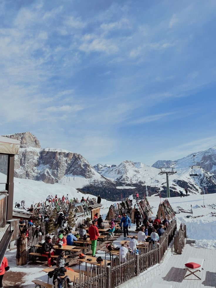 This may contain: a group of people standing on top of a snow covered slope