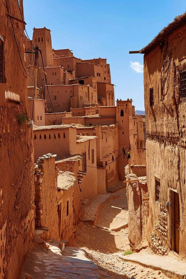 This may contain: an alley way in the desert with adobe buildings and cobblestone streets on both sides