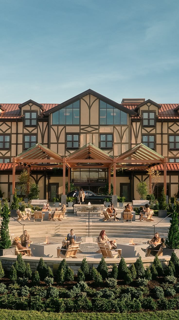 This may contain: a large building with lots of windows and people sitting on benches