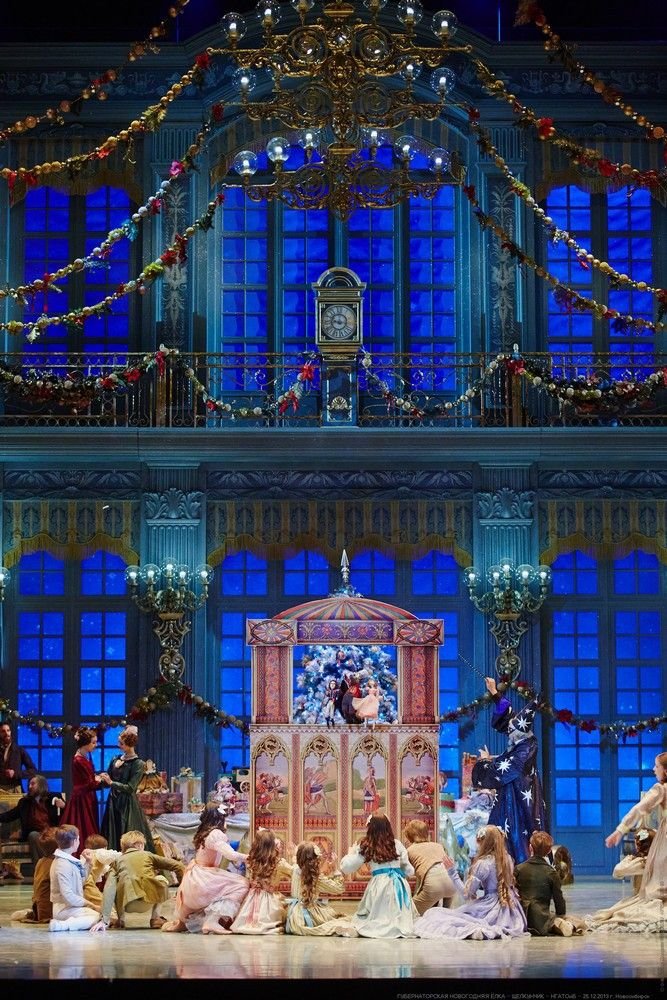 This may contain: a group of people sitting on top of a stage in front of a building with blue windows