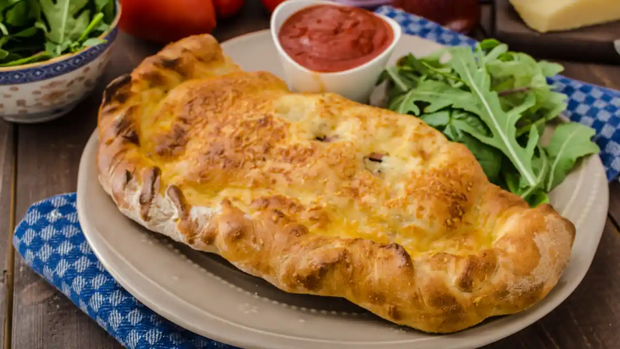 Calzone pizza with cheese and prosciutto for National Calzone Day