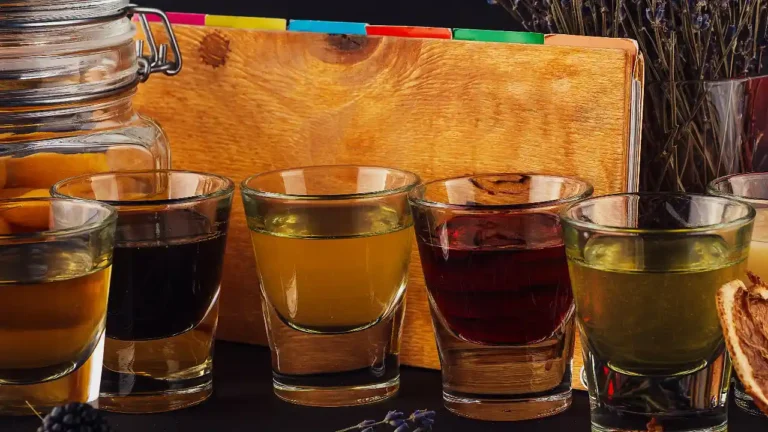 Multicolored transparent cocktails in a row, celebrating National Liqueur Day