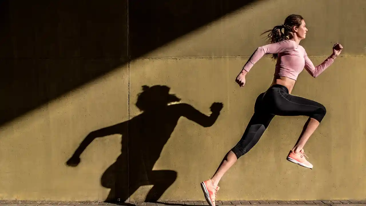 Young fit blonde woman jumping in the street for National Biomechanics Day.