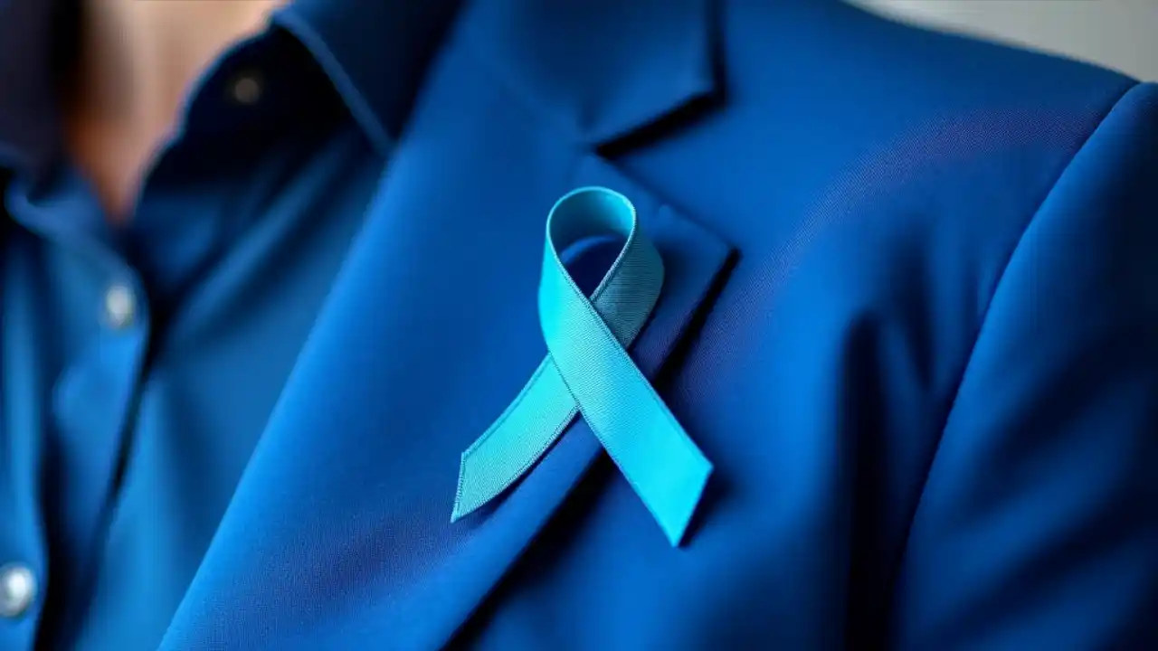 A person wearing a blue ribbon pin on their lapel to raise awareness for colorectal cancer screening and prevention