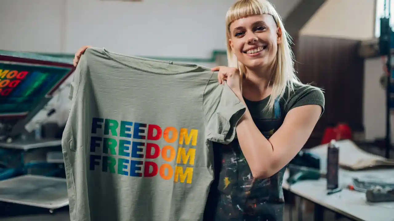 Smiling print shop worker showcasing silkscreen printed 'National Pro-Life T-Shirt Day' design