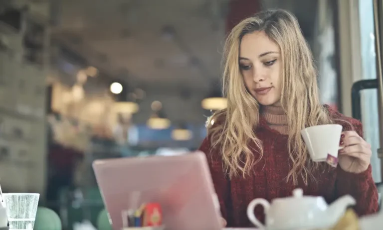 Young woman in a café, celebrating National Screenwriters Day.