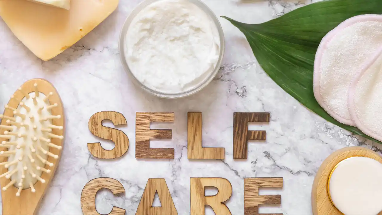 SElf Care text with cosmetics and skincare accessories for National Self Care Day.