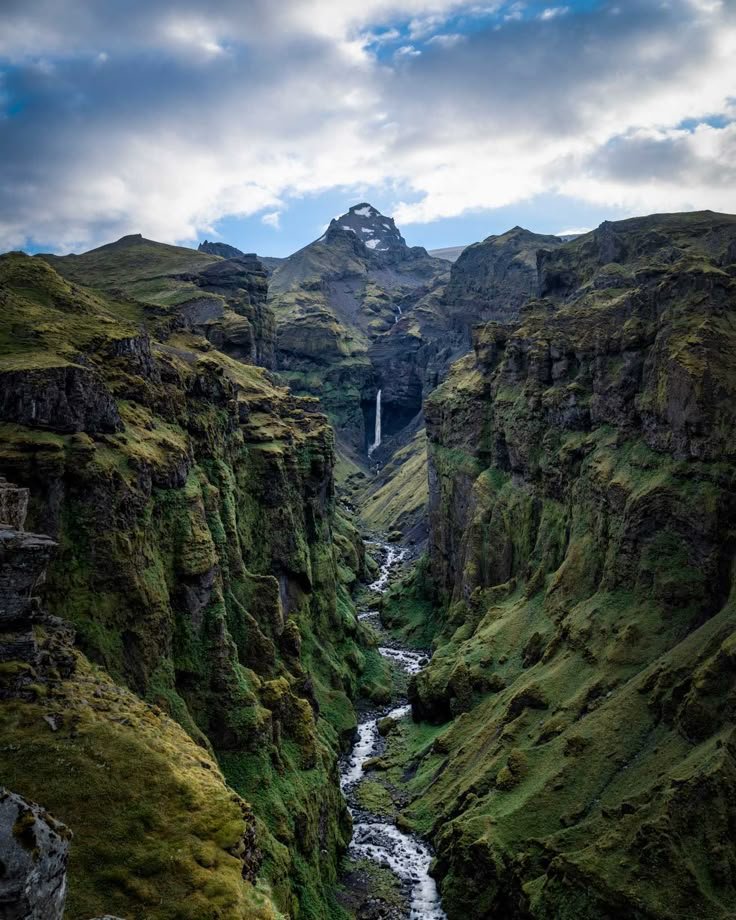 This may contain: a river running through a lush green valley