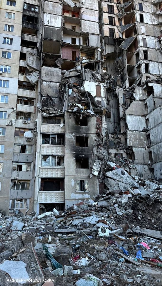 This may contain: a very tall building with lots of windows and debris on the ground in front of it
