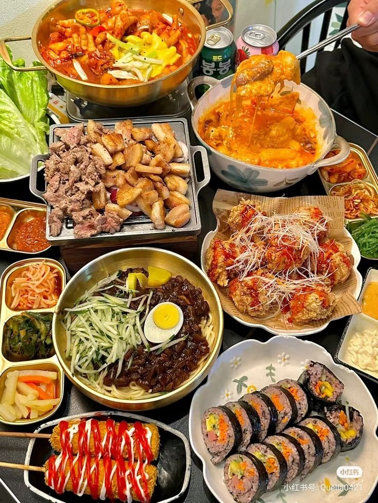 This may contain: a table topped with lots of different types of foods and dishes filled with meats