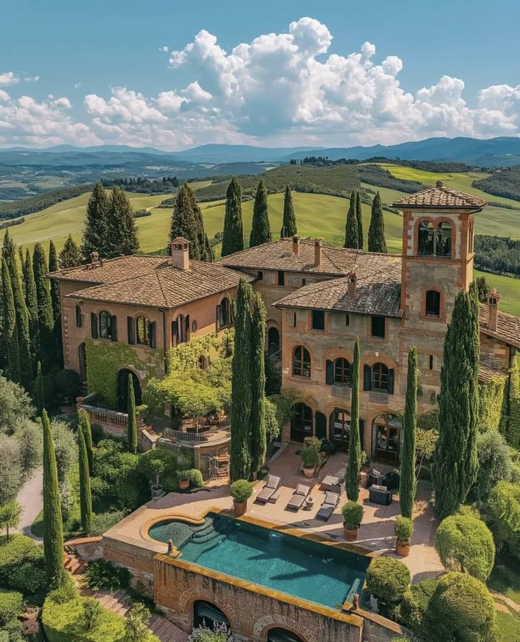 This may contain: an aerial view of a large home surrounded by trees and greenery with a swimming pool in the foreground