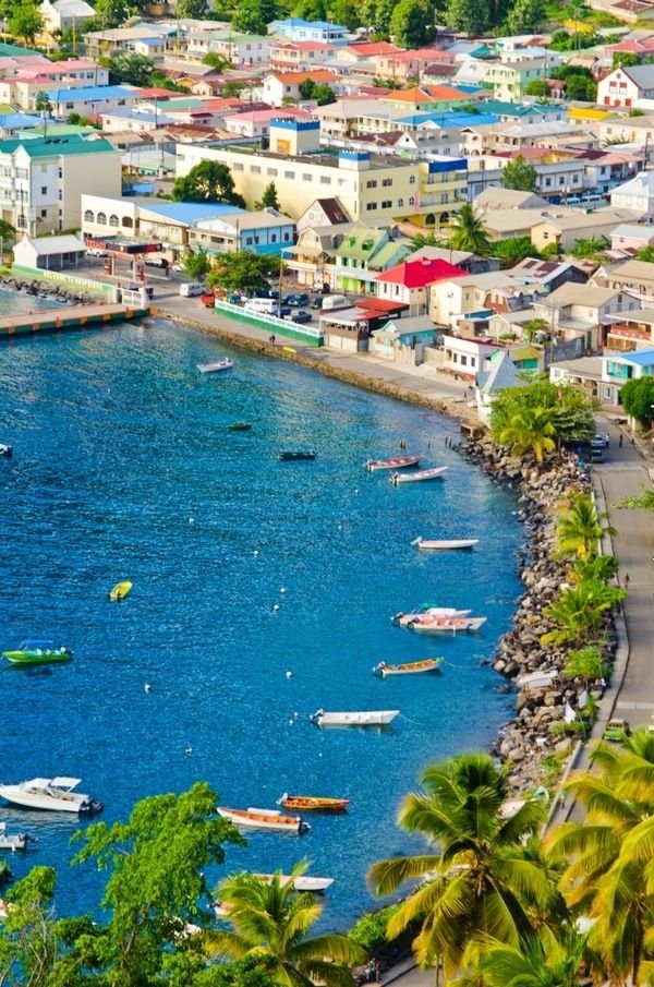 This may contain: an aerial view of a city with boats in the water and palm trees surrounding it