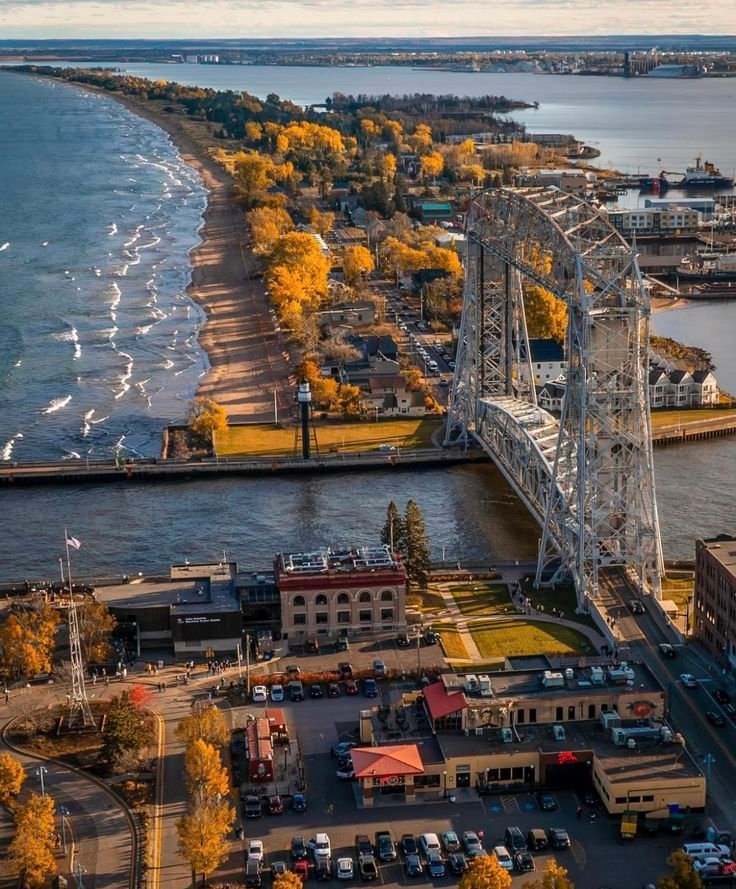 This may contain: an aerial view of a bridge spanning the width of a large body of water with cars parked on it